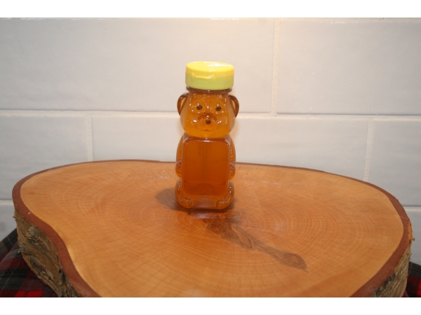 K and J Apiaries Liquid Raw Honey Bear in an 8 ounce squeeze bottle.